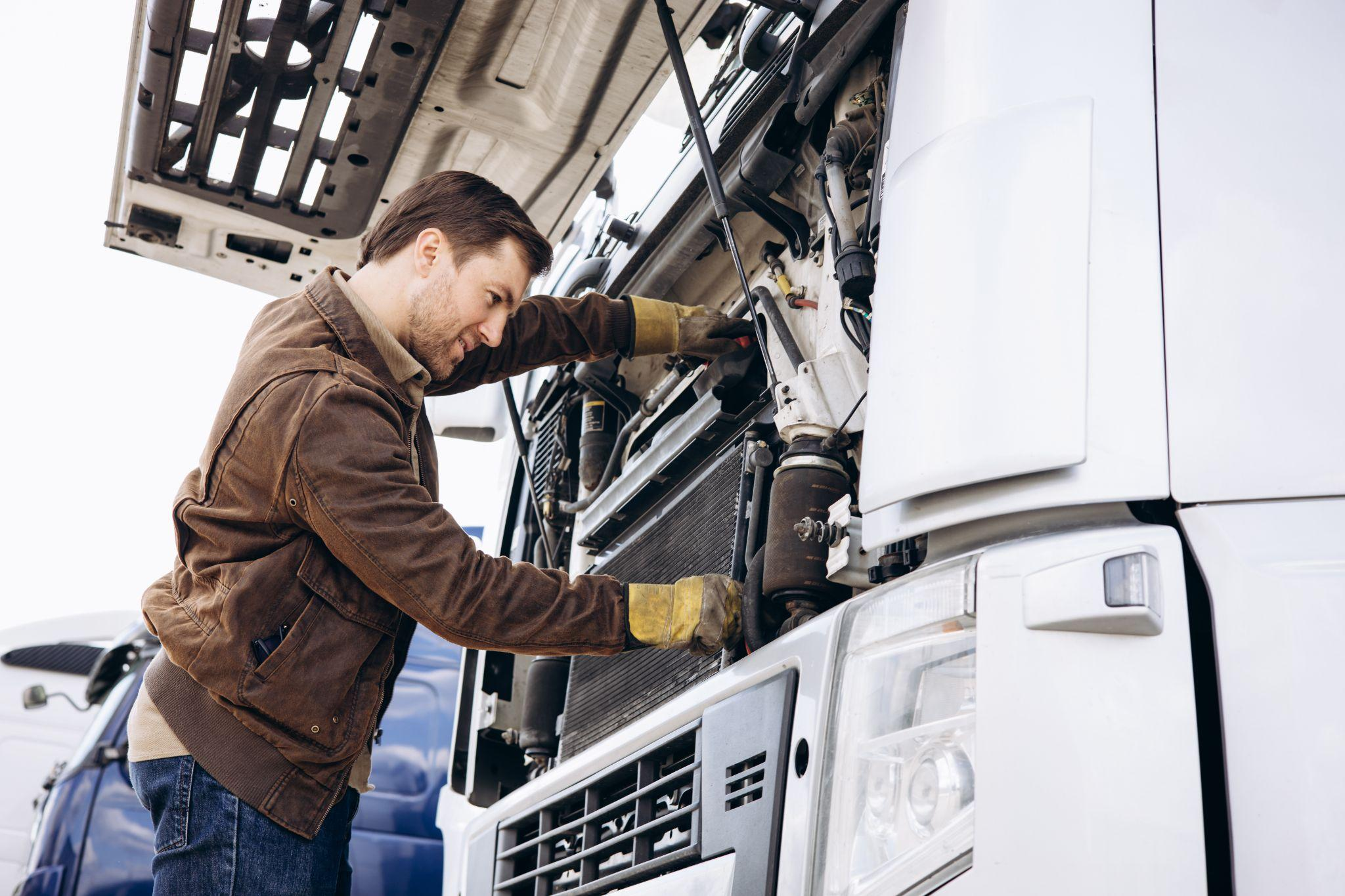 Mechanic conducting engine repairs on a truck
